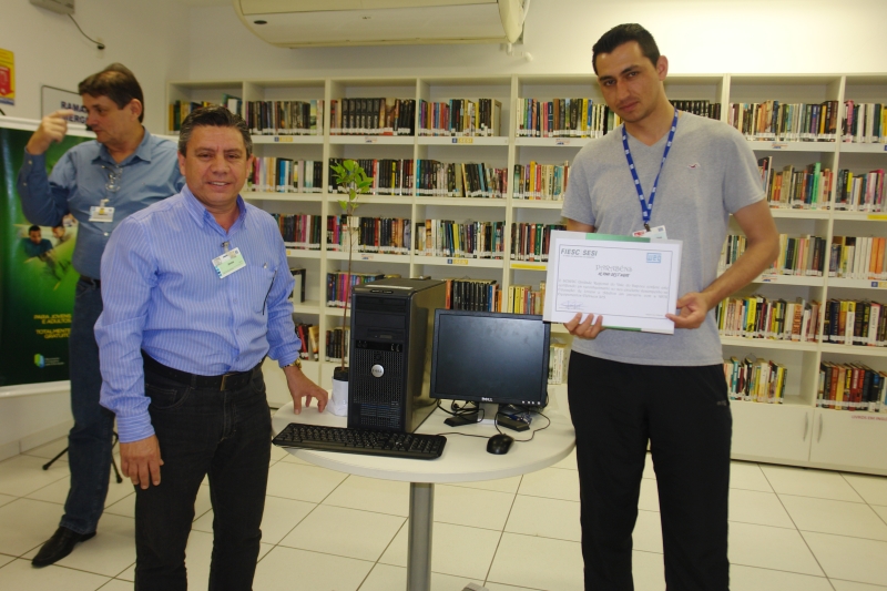 Jean Carlos dos Santos recebendo o computador do Chefe João Carlos da Silva (Foto: Divulgação/WEG)